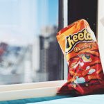 bag of spicy Cheetos by a window