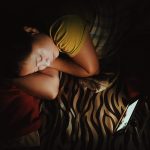 Girl in bed watching something on her device
